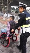 残疾人坐轮椅车流中行驶 民警护送至地铁站