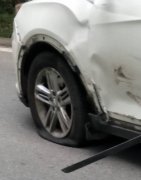 小轿车和摩托转弯处“互怼” 左前轮都撞爆了
