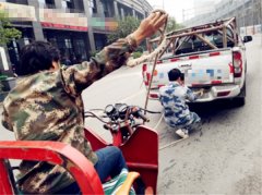 皮卡车麻绳牵引三轮 街头上演“老牛拉车”