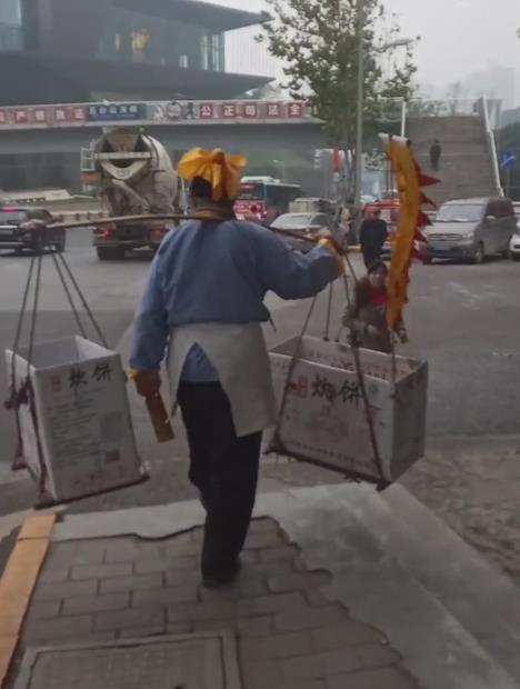 “武大郎”重庆街头挑担买饼  引路人侧目