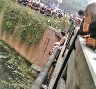 脱光衣服坐在桥上 男子险些掉入河中