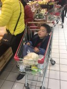 陪妈妈外婆过节 小男孩购物车里睡着了