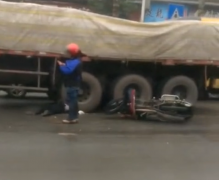 摩托与大货车相撞 驾驶员被压车轮下