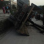 垃圾拖车掉下坎侧翻倒地 汽油流满地