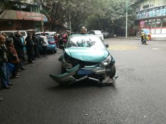 出租车十字路口吻上私家车 车头碎裂一地
