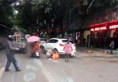 白色轿车倒车时  压到环卫工的腿