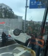 白色轿车四脚朝天躺在地上   路人：怎么开的？