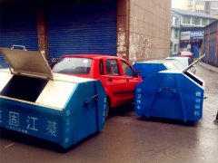 三轮车停路边 遭垃圾箱“围攻”进退两难