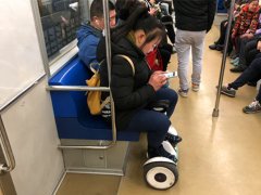 女子车厢内踩“风火轮”    专注玩手机