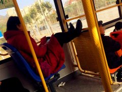 女子乘公交坐姿霸气  双脚搭在护栏上玩手机