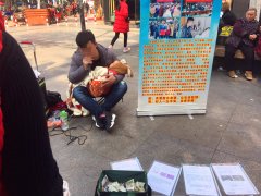 男子抱娃街头唱歌乞讨  市民扫码支付