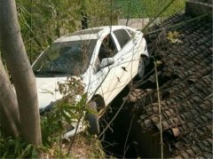 轿车开上瓦房屋顶 悬半空中很惊险