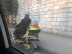 男子载娃反坐电瓶车  小孩趴在货箱呼呼大睡