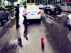 轿车雨中抛锚 竟用灭火器充当警示牌