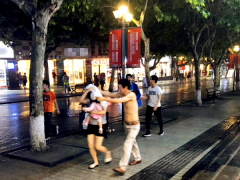 暴雨突降令人措手不及 男子脱衣为女童女子挡雨